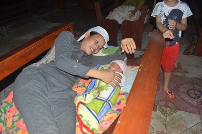 Em bé 5 tháng tuổi cùng mẹ sơ tán tránh lũ trong đêm 