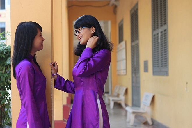 Chiếc áo dài tím nổi bật giữa không gian hành lang cổ kính của trường. 