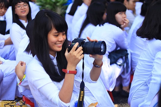 Một nữ sinh thích thú xem lại những bức hình mình chụp. 