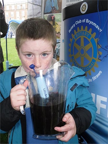 Cậu bé Oliver 7 tuổi đang thưởng thức 'nước bẩn' bẳng ống hút Lifestraw tại triển lãm ở trường Green Bristol. 