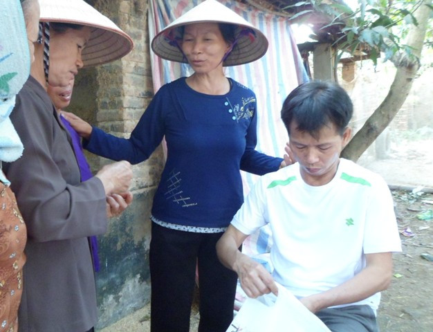 Ông Nguyễn Thanh Chấn được bà con lối xóm đến thăm hỏi khi được trở về nhà sau 10 năm tù. (Ảnh. Xuân Hải).