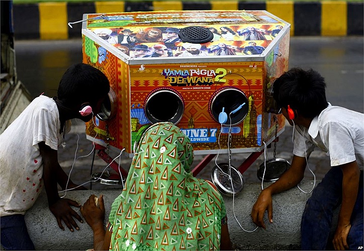 Người phụ nữ và hai cậu bé đang xem trailer phim “Yamla Pagla Deewana 2” bằng một cái máy truyền thống