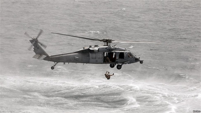 Thợ lặn Hải quân Mỹ cắt dây để khỏi bị kẹt vào một dụng cụ an toàn khi nhảy khỏi một máy bay trực thăng