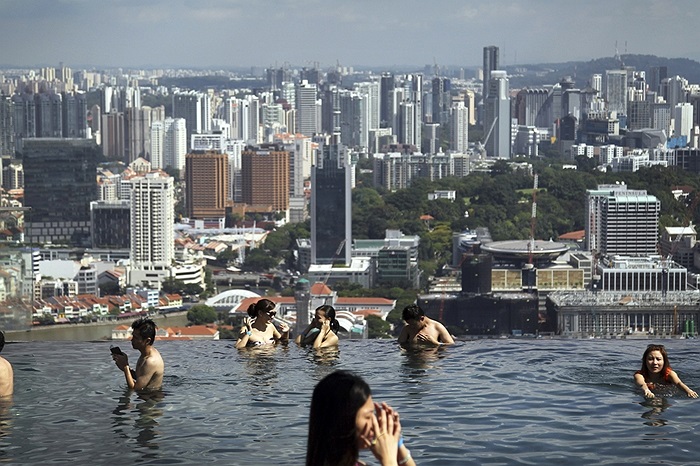 Du khách đắm mình trong bể bơi trên nóc tòa nhà chọc trời ở Singapore