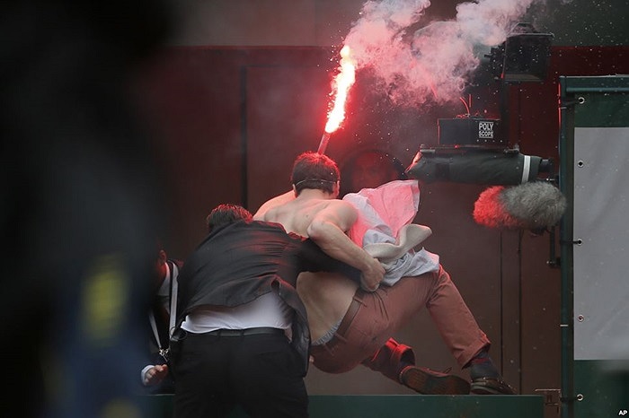 Nhân viên bảo vệ đưa một người biểu tình ra khỏi khu vực diễn ra giải chung kết tennis ở Paris, Pháp