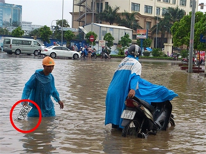 Nhiều người nhặt được biển số ô tô trên đường ngập nước. (Ảnh TPO).