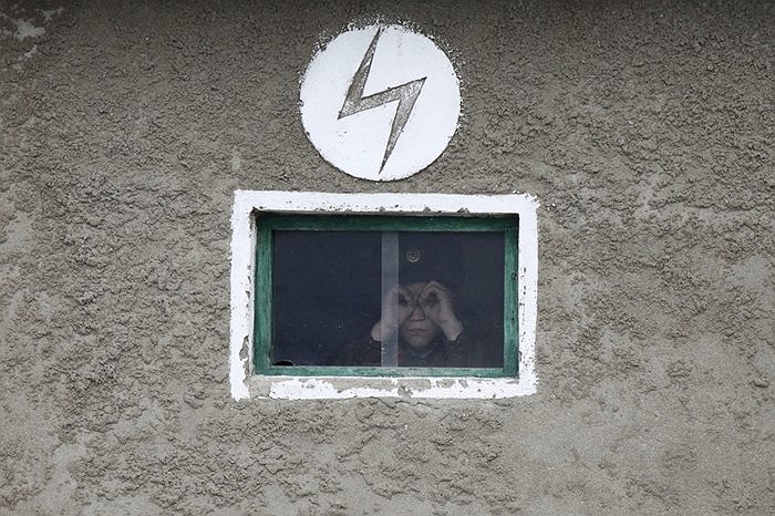 Người lính Triều Tiên nhìn sang Trung Quốc qua ô cửa kính ngôi nhà kề sông Áp Lục