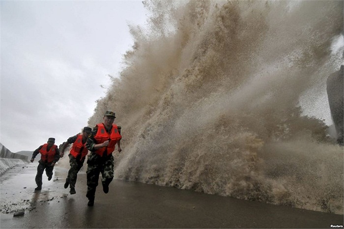 Lính biên phòng chạy qua sóng lớn do bão Fitow gây nên tại Ôn Lĩnh, tỉnh Chiết Giang, Trung Quốc