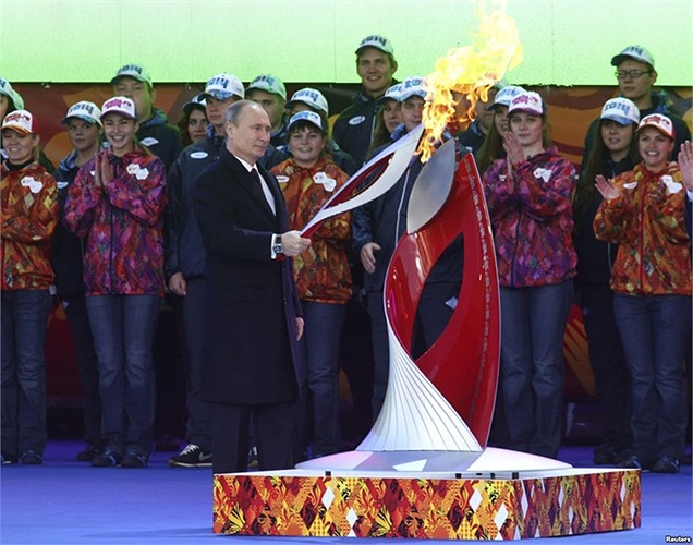 Tổng thống Nga Vladimir Putin cầm ngọn đuốc Olympic được thắp lửa trong buổi lễ để đánh dấu khởi đầu hành trình rước đước Thế vận hội mùa đông Sochi 2014