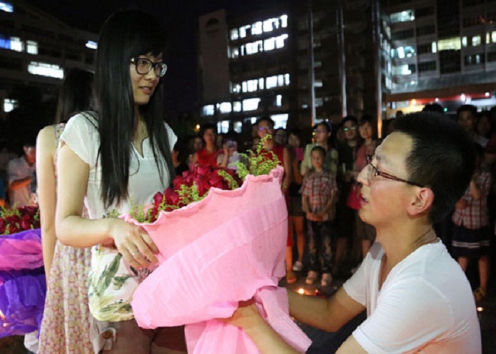 Nam sinh tên Li Shipeng, 23 tuổi quỳ xuống và tặng hoa cầu hôn cô bạn gái xinh đẹp tên Zou Yang, 22 tuổi. 