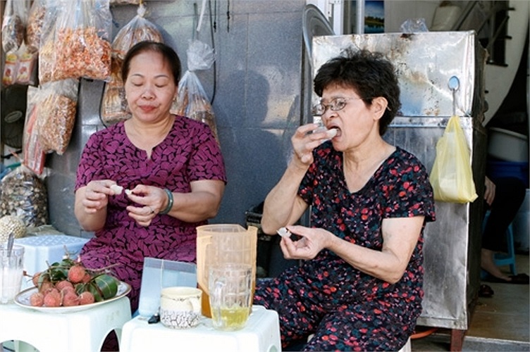 Hai người bạn già đang ngồi ăn vải và uống nước chè xanh để 'diệt sâu bọ'. (Ảnh: PetroTimes)