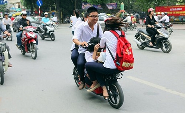 4 học sinh không đội MBH, ngồi nhồi nhét trên chiếc xe đạp điện. Ảnh chụp trên phố Tây Sơn, Hà Nội (Ảnh: Khám phá)