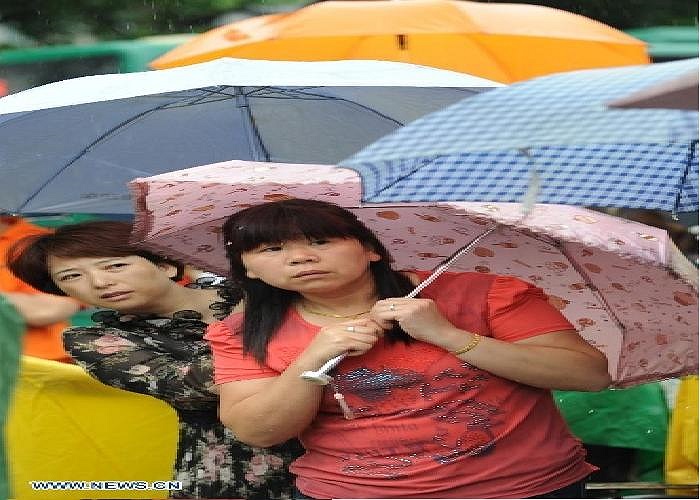 Hai khuôn mặt lo âu của phụ huynh hướng về nơi con cái đang thi đại học.