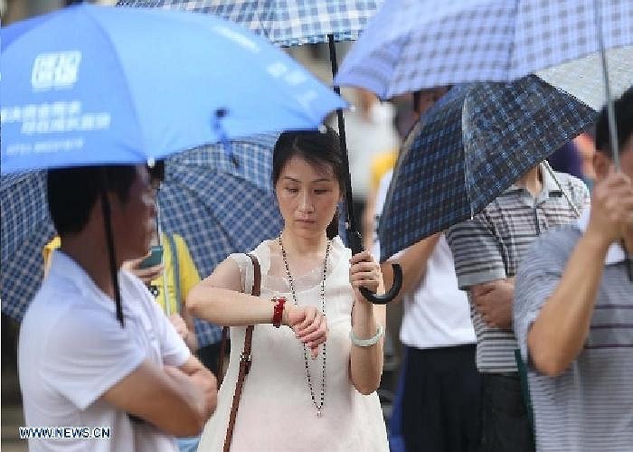 Người mẹ nhìn đồng hồ sốt ruột đợi con trai đang thi bên trong.