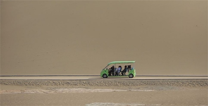 Một chiếc xe mang khách du lịch đến vùng ốc đảo, địa danh đã có từ thời nhà Hán của Trung Quốc