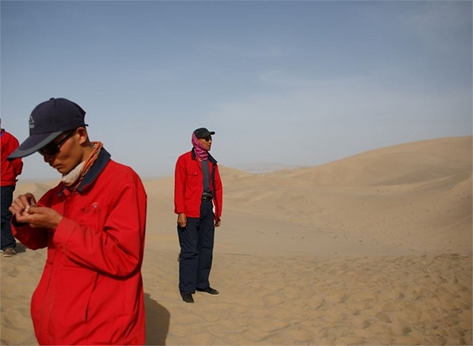 Những hướng dẫn viên du lịch mặc áo đỏ đặc trưng đứng đợi khách