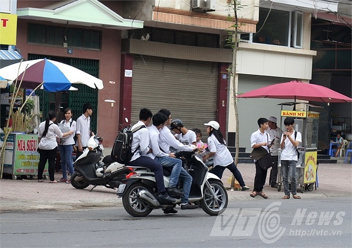 Học sinh kẹp ba, phóng nhanh, không đội mũ bảo hiểm sau giờ thi.