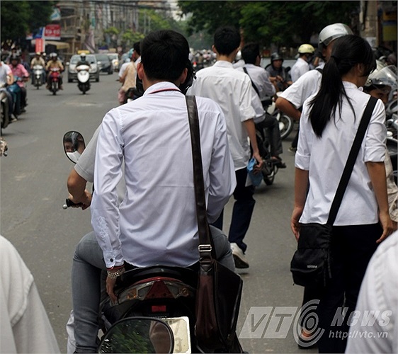 Bước ra khỏi trường thi, nam sinh này bước vội lên xe, trong khi phụ huynh cũng không nhắc nhở con em mình đội mũ bảo hiểm.
