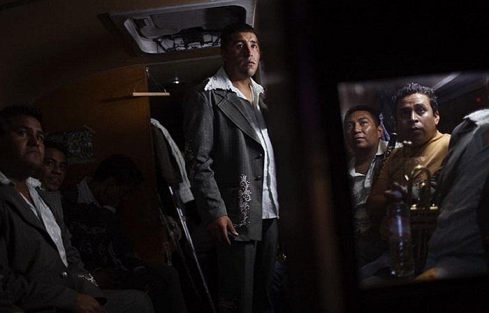 Một nhóm người chuyên phục vụ các hoạt động văn nghệ quần chúng ngồi trong xe khi di chuyển qua Mexico City