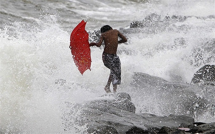 Cậu bé Philippines liều mình đi qua đoạn đê đang chịu ảnh hưởng của cơn bão nhiệt đới Kong-Rey 