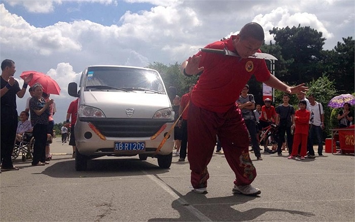 Bậc thầy kungfu Feng Guoyi kéo một chiếc xe đi 20m bằng dây thừng với dao kề cổ ở Trường Xuân, tỉnh Cát Lâm, Trung Quốc