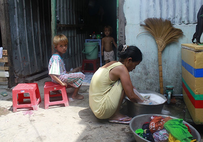 Khi con trai đầu lòng mới biết bò, chị mang bầu đứa thứ 2. Điệp khúc đẻ - mang bầu - đẻ cứ lặp đi lặp lại và 9 đứa trẻ chào đời trong 12 năm đối với vợ chồng này trôi qua rất… nhẹ nhàng. Ảnh: chị Gái giặt đồ cho con.