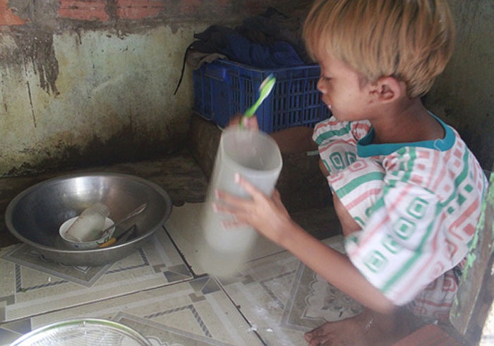 bé Nguyễn Ngọc Bảo (con thứ 7) đánh răng sau khi các anh chị đã đánh xong...