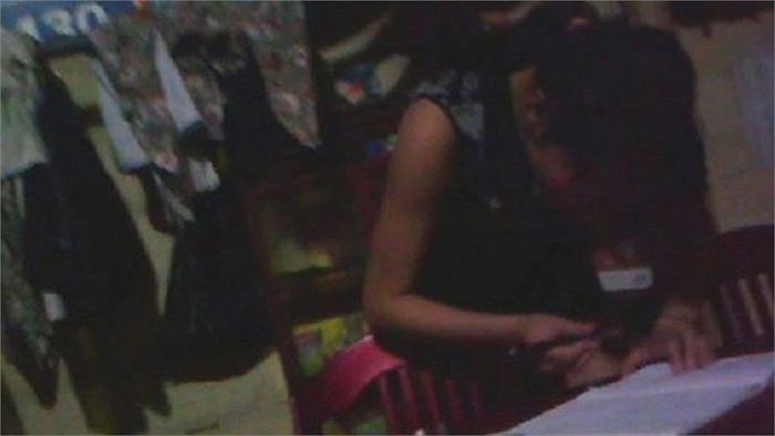 Sau khi gặp khách, cô gái này ký vào sổ để ghi công.