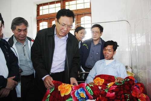 Bộ trưởng Phạm Vũ Luận lật chăn xem kỹ các vết thương của giáo viên gặp nạn đang điều trị tại Bệnh viện huyện Sa Pa sáng nay (6/9)