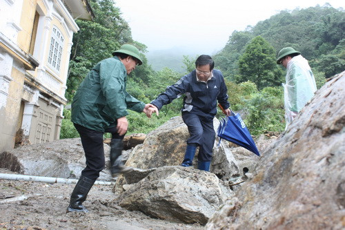 Đoàn công tác vất cả leo qua những tảng đá to như tấm phản để đi sâu vào hiện trường