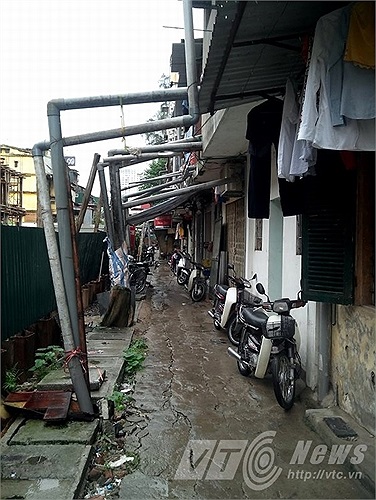 Hàng trăm ống dẫn nước thải từ các căn hộ trong khu tập thể bắc qua đầu người đi đường.