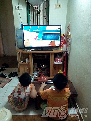 Nhà chật, các cháu nhỏ phải ngồi sát màn hình tivi xem phim.