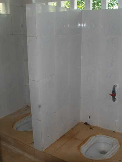 Bệ ngồi tiểu phòng vệ sinh nữ sinh trống trơn, không cửa