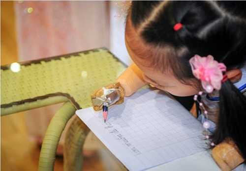 Linh Chi viết chữ trên đôi bàn tay giả.