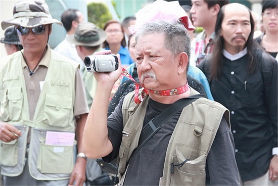 Nghệ sĩ Mạc Can tranh thủ quay hình lễ tang. 