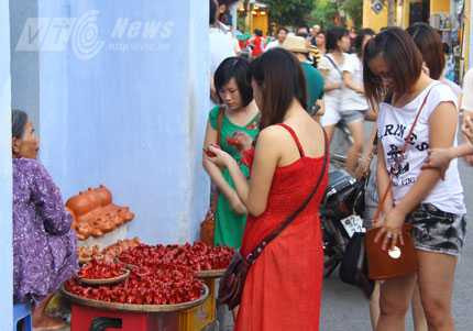 Du khách thích thú chọn mua quà lưu niệm tại phố cổ Hội An 