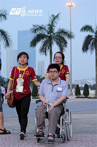 Các tình nguyện viên giúp đỡ một bạn phải ngồi xe lăn tới xem Nick.