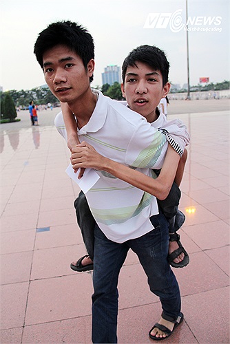 Một bạn trai bị liệt 2 chân được bạn cõng đến buổi giao lưu với Nick.