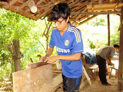 Trần Thanh Hoàng đang cùng cha làm đồ mộc .