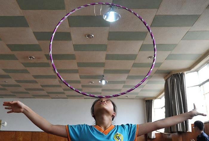 Một học sinh của trường Cao đẳng nghệ thuật Xiếc Đài loan đang tập luyện với chiếc vòng tại tỉnh Yunnan (Trung Quốc).