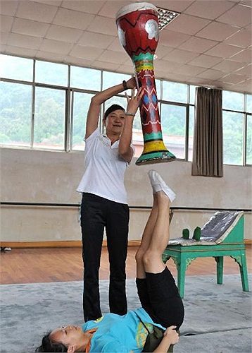 Giáo viên giúp đỡ học sinh giữ thăng bằng một nhạc cụ.