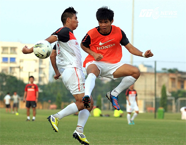 Trung vệ Gia Từ (áo cam) vào bóng mạnh mẽ trước hậu vệ cánh Hoàng Quãng.