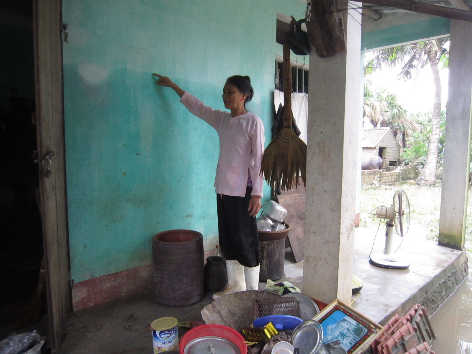 Người dân thôn 4 xã Tân Trường (Tĩnh Gia) chỉ mực nước ngang đầu lúc cơn lũ lên cao nhất.