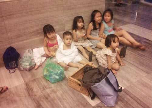 Nhiều trẻ em phải mặc nguyên đồ bơi ngồi chờ phòng gửi đồ mở cửa