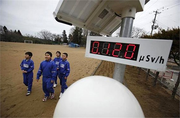 Học sinh Nhật Bản đi bộ gần đồng hồ đo độ phóng xạ, cách nhà máy điện hạt nhân Fukushima, Daiichi 13 dặm