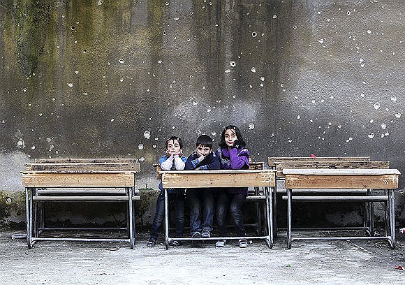 Các em học sinh ngồi trên ghế tại trường Al Tawheed trong cuộc nội chiến Syria