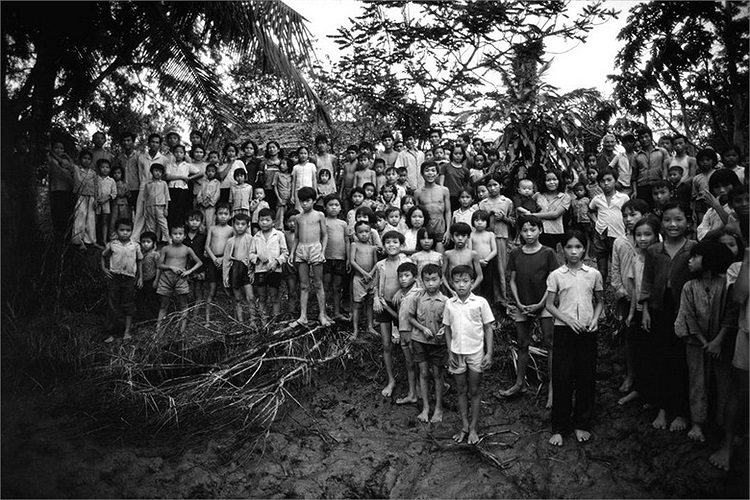 Những đứa trẻ hiếu kỳ tập trung bên bờ sông ở đồng bằng sông Cửu Long để ngắm các phóng viên ngoại quốc. Việc kết thúc cuộc chiến đã khiến dân số Việt Nam bùng nổ.