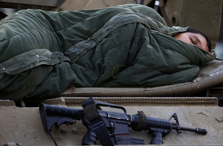 Lính Israel ngủ trên nóc xe bọc thép chở quân tại căn cứ của Israel gần trung tâm Gaza, ngày 21/11/2012.