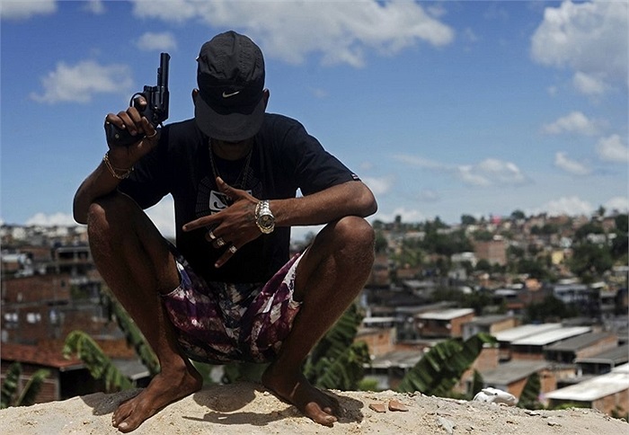 Một tên côn đồ thuộc các băng đảng buôn ma túy chụp ảnh với khẩu súng trên tay tại khu ổ chuột ở Salvador