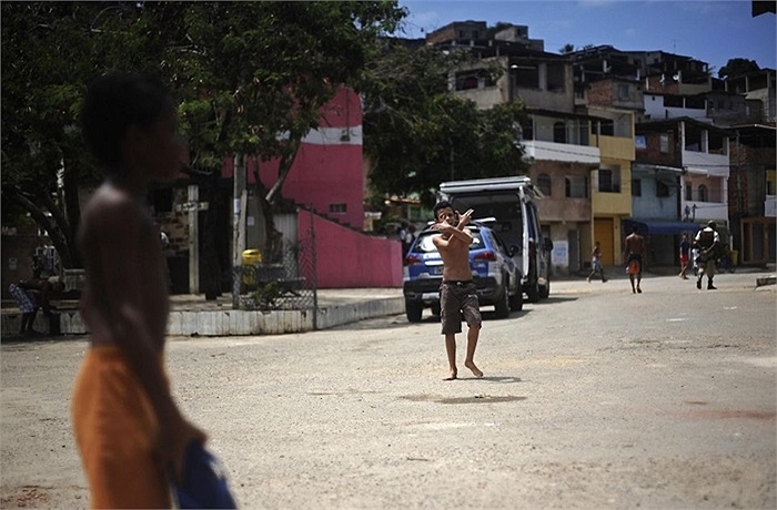 Cậu bé làm dấu hiệu súng đôi khi chơi đùa trên đường phố